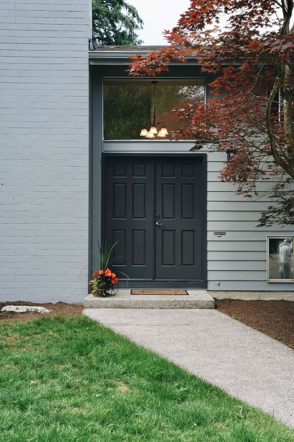 Repainted front entry of a Kirkland home with crisp charcoal doors and light gray siding